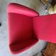 Old cinema chair with a red reclining seat.