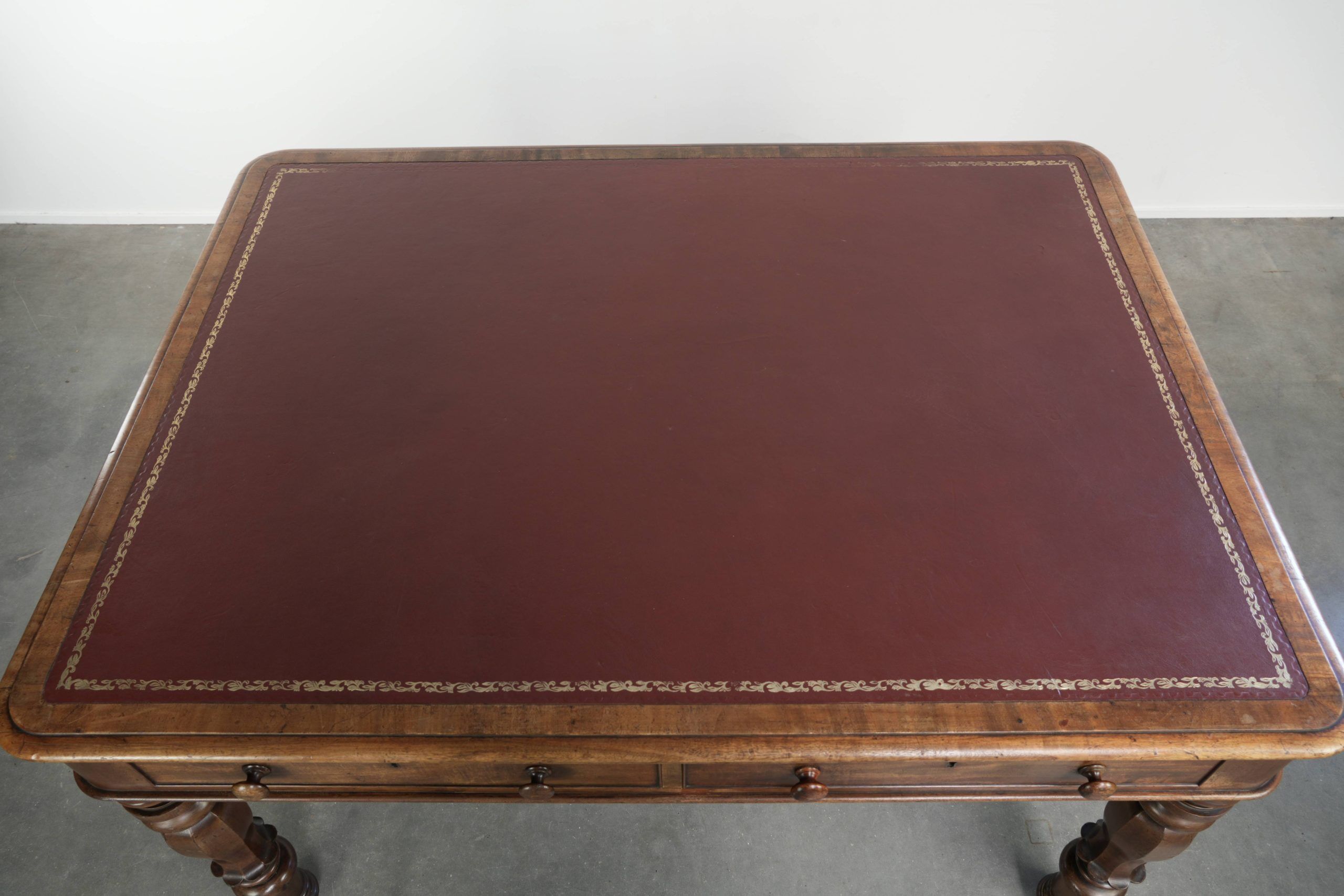 Antique English writing desk from the 19th century with a red leather top