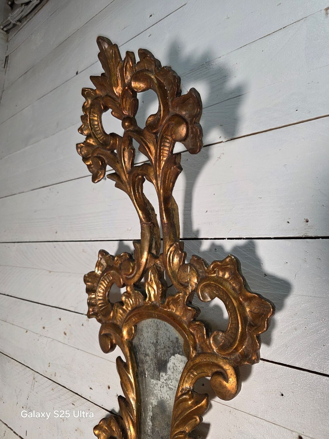 Italian mirror in gilded wood with gold leaf from the 18th century.