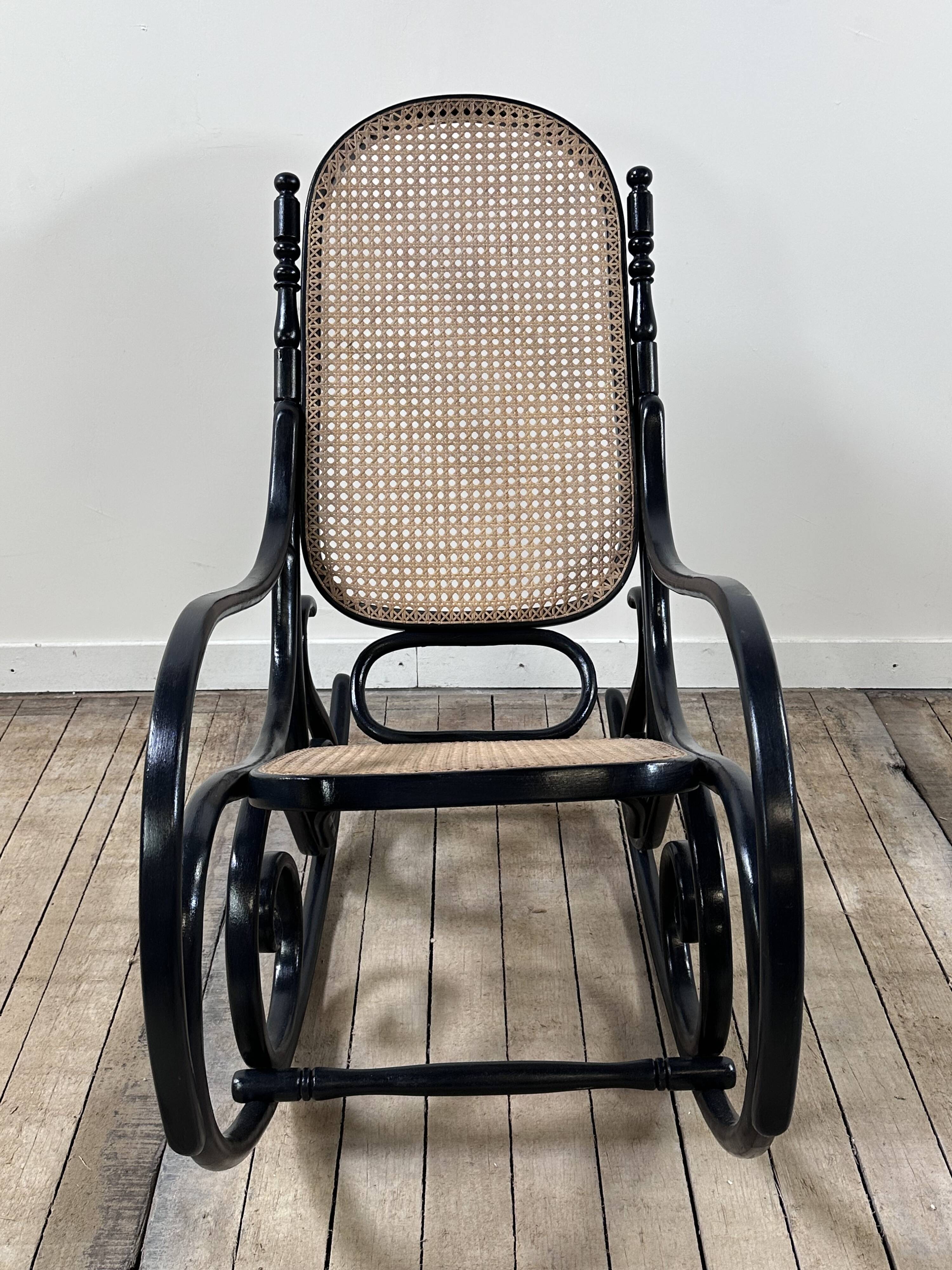 Rocking-chair en bois courbé noirci et cannage années 1900