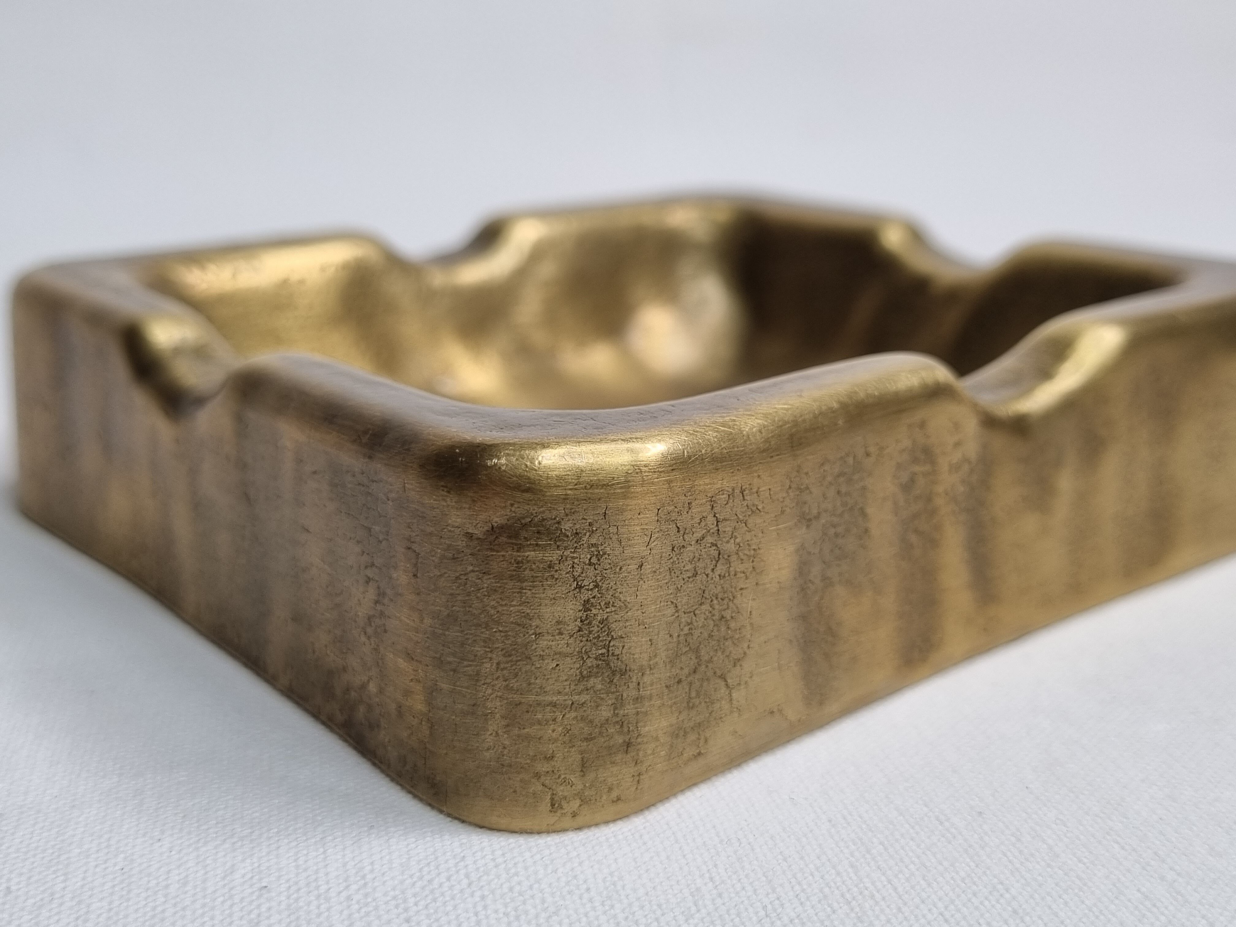 Empty pocket brutalist-inspired ashtray in gilded bronze