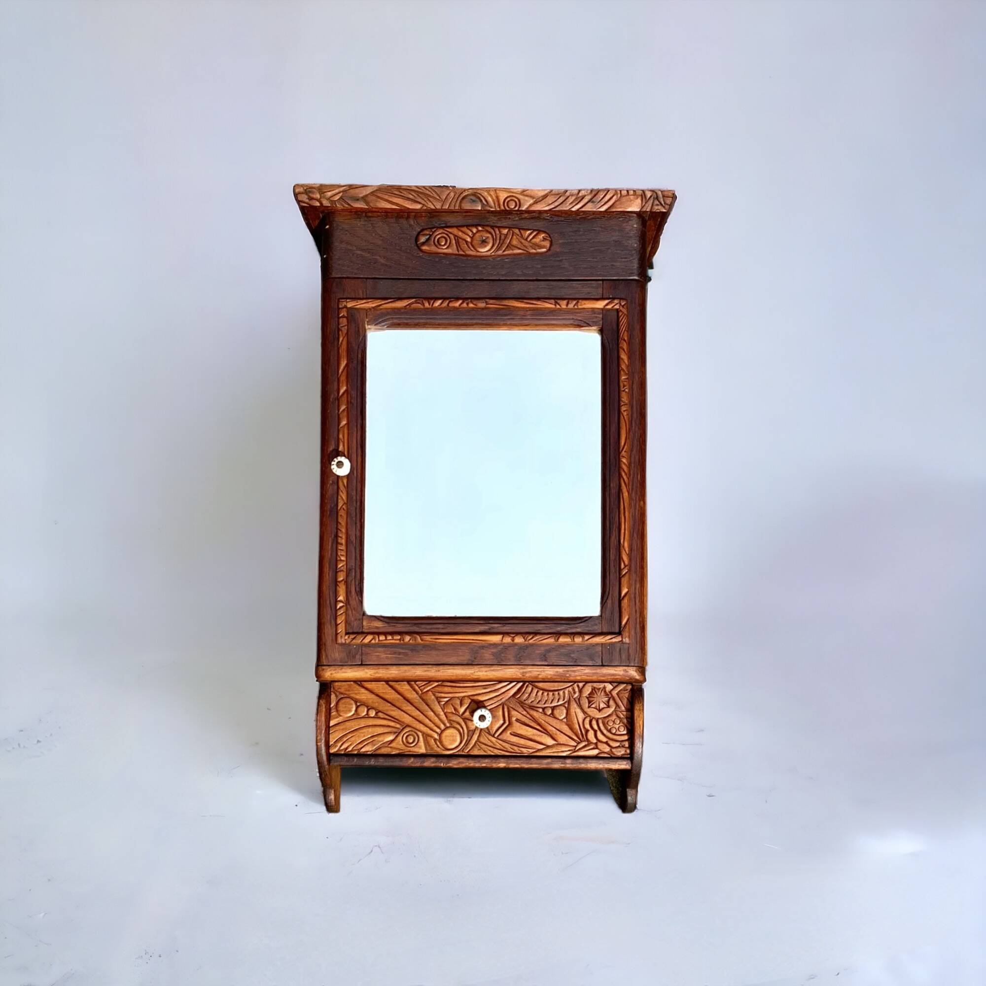 Old carved wooden medicine cabinet with beveled mirror