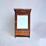 Old carved wooden medicine cabinet with beveled mirror