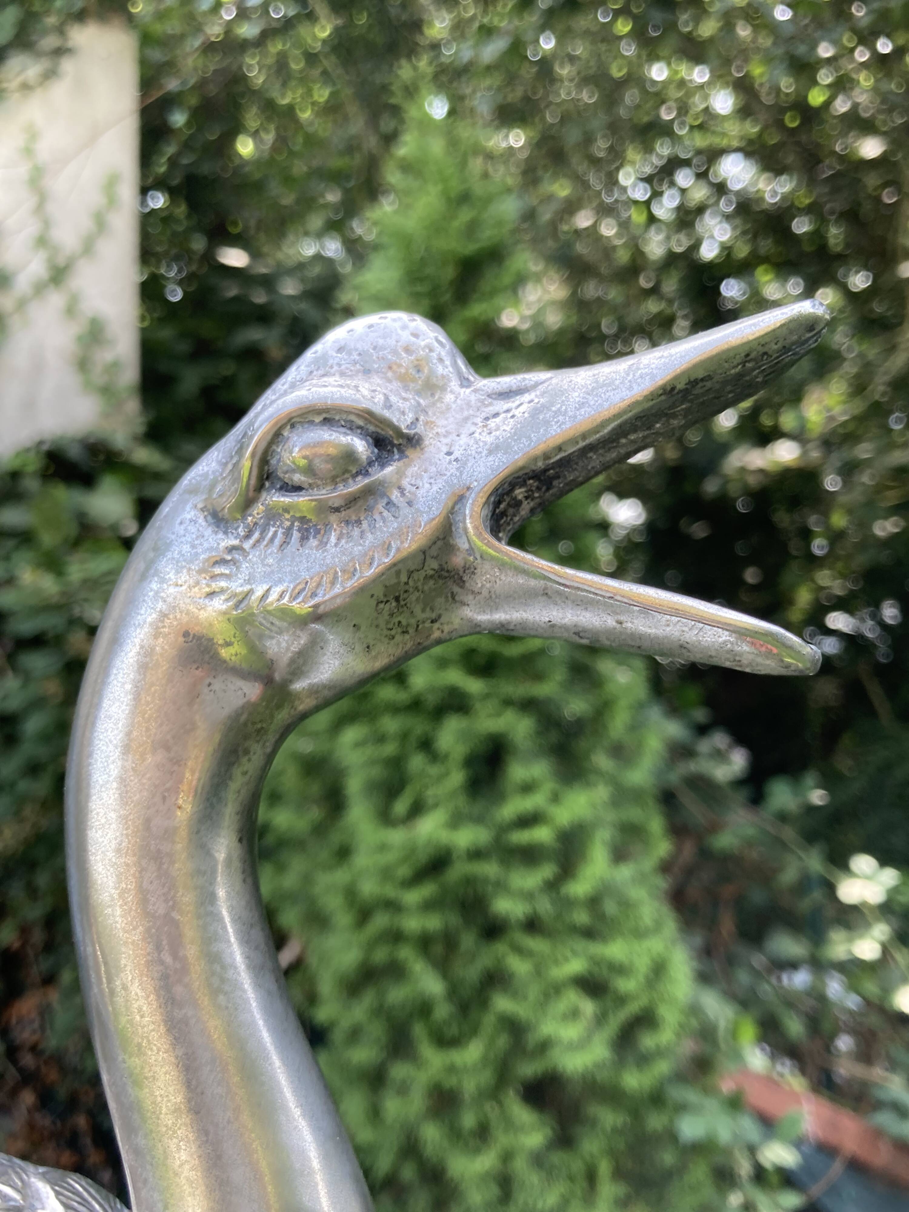 Old vintage lamp representing a duck in silver metal with wooden base