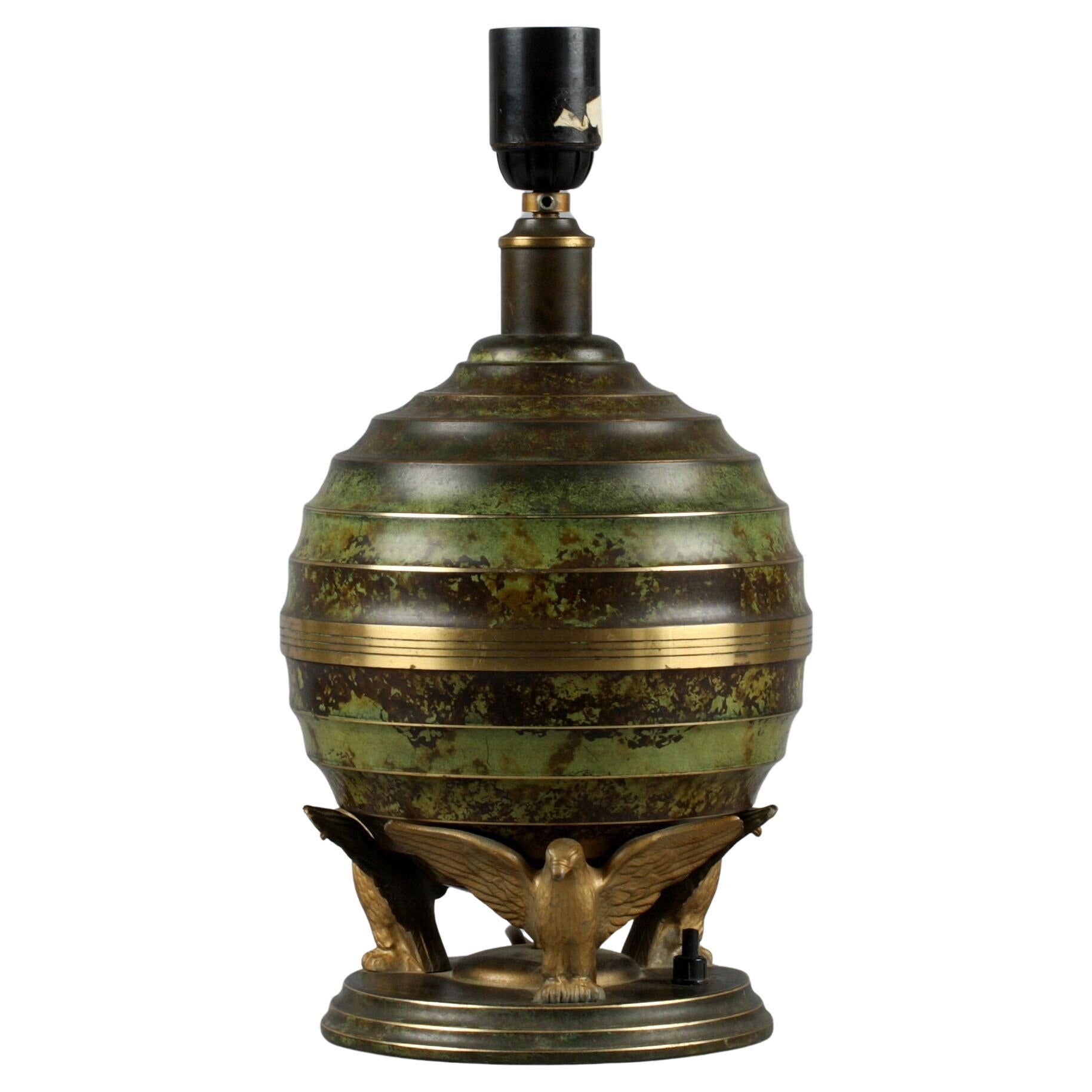 Art Deco table lamp in patinated bronze with eagles holding a globe, France 1940.