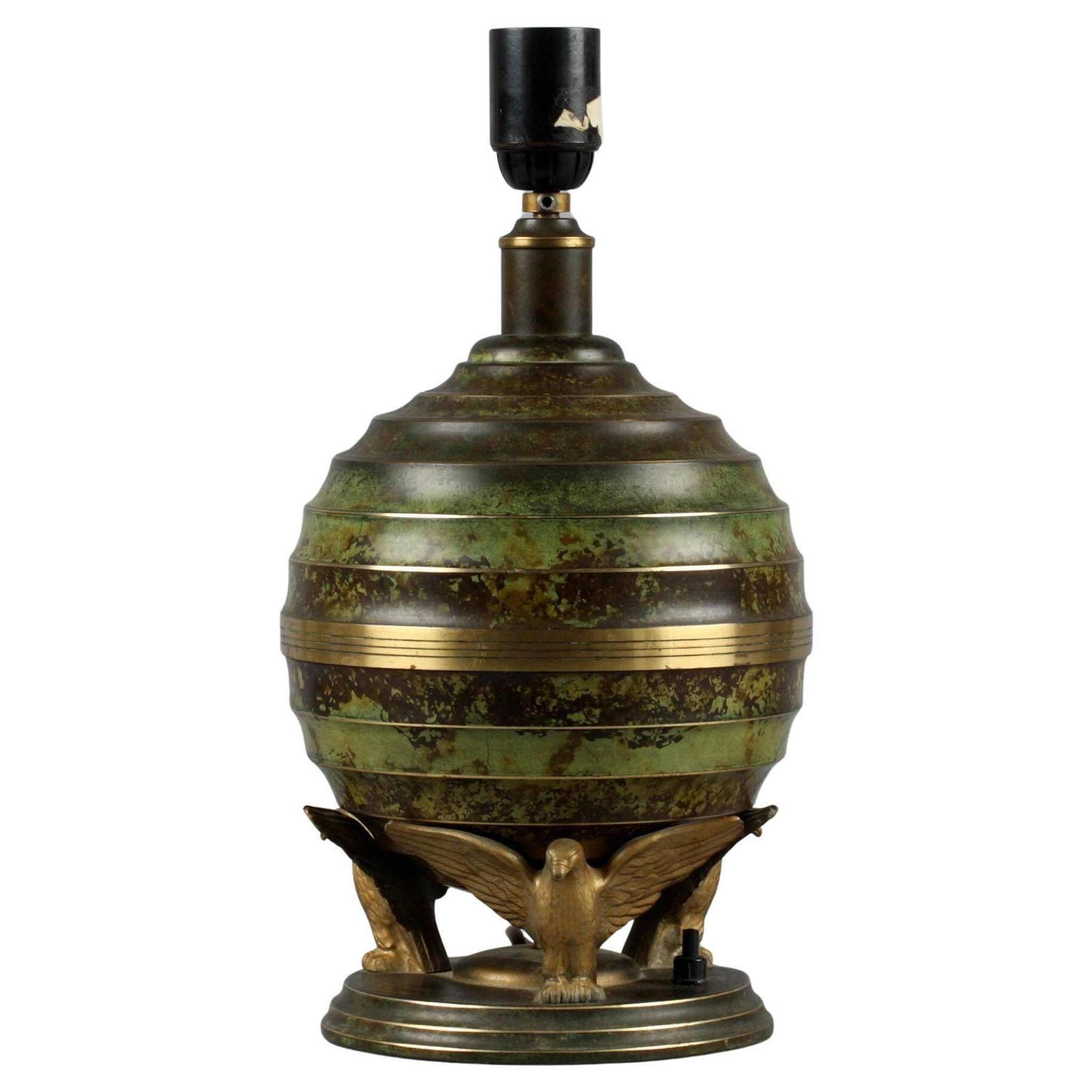 Art Deco table lamp in patinated bronze with eagles holding a globe, France 1940.