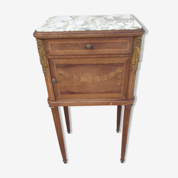 Old wooden bedside table on marble top