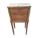Old wooden bedside table on marble top