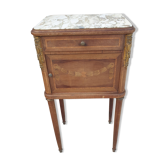Old wooden bedside table on marble top