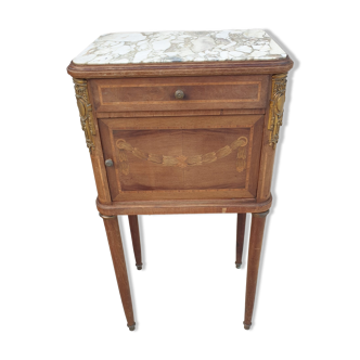 Old wooden bedside table on marble top