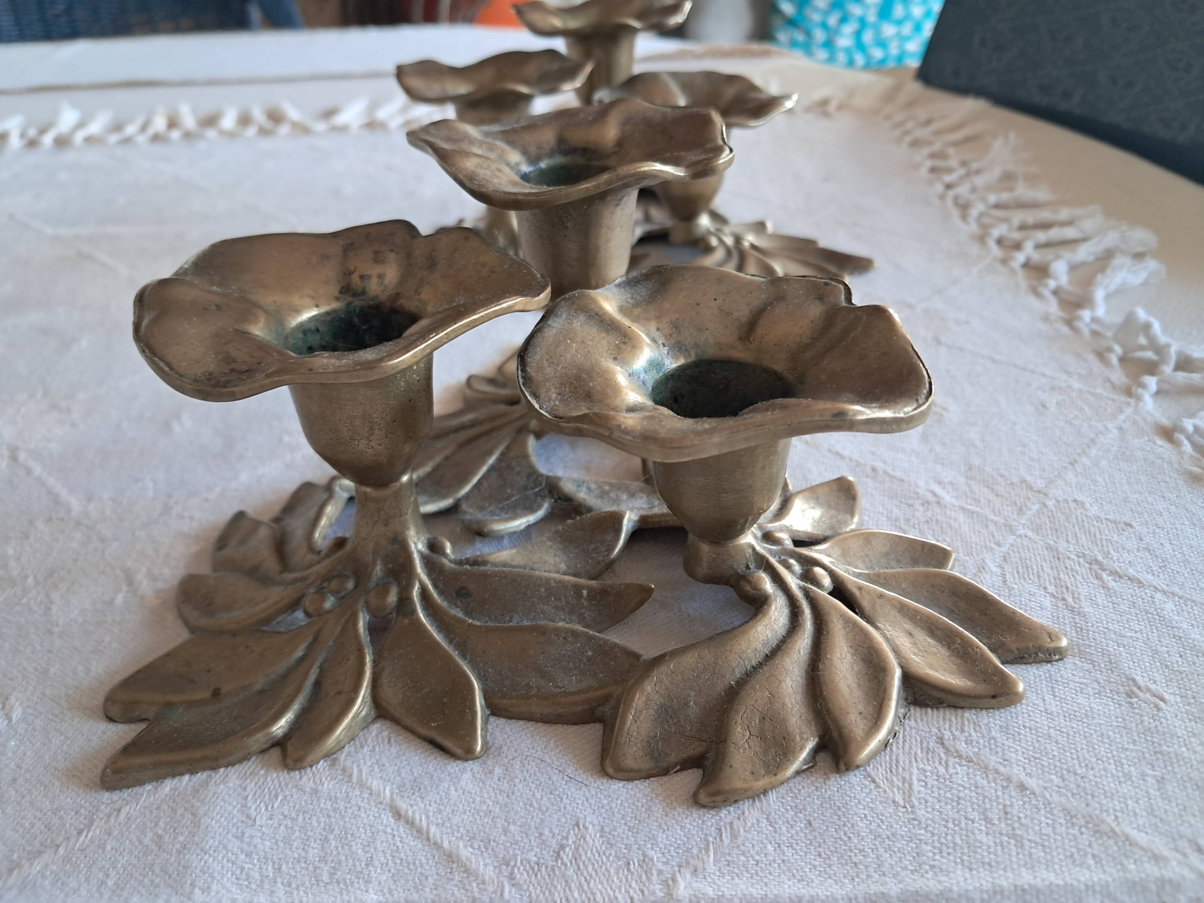 Pair of antique three-branch candlesticks with a floral design.