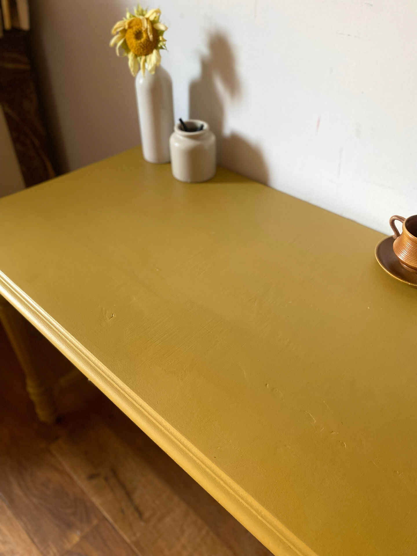 Desk table from the late 19th century, painted mustard, with turned stretcher.