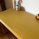 Desk table from the late 19th century, painted mustard, with turned stretcher.