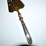 Antique silver-plated pie server with a brass blade decorated with roses.