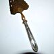 Antique silver-plated pie server with a brass blade decorated with roses.