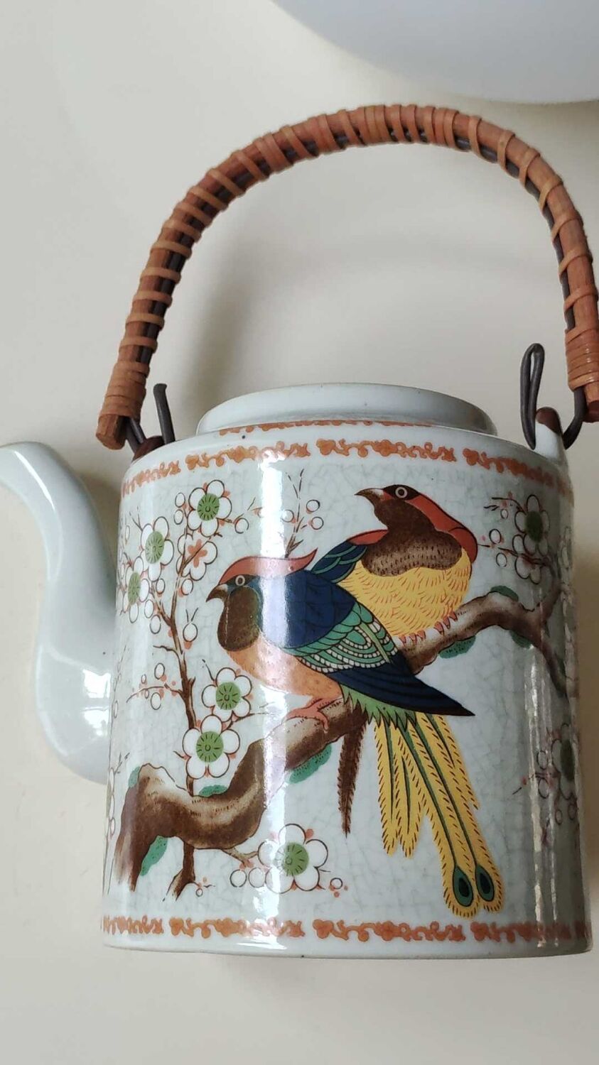 Japanese ceramic teapot. bird/paradise motifs/cherry trees. bamboo/rattan braided handle