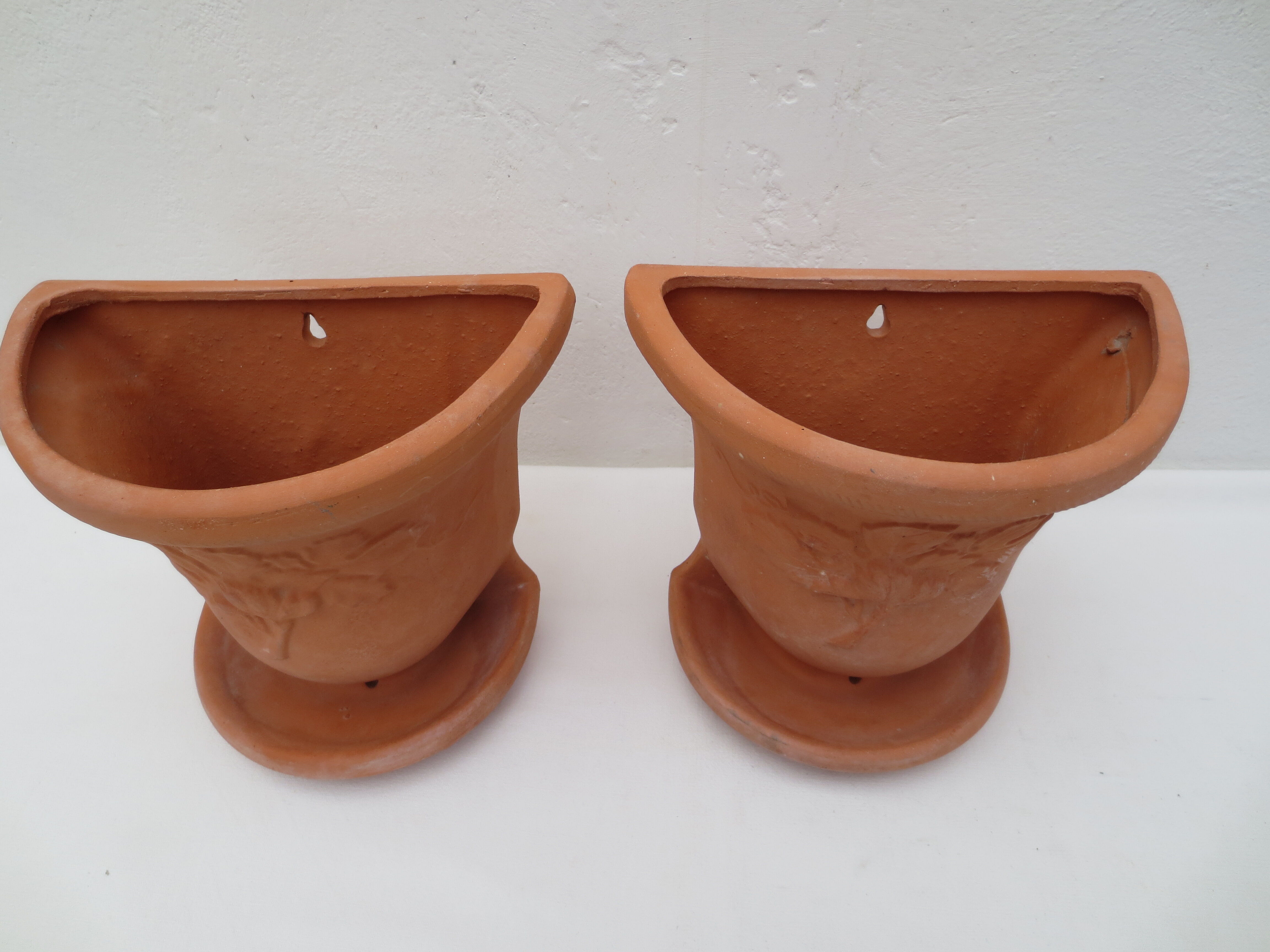 Duo of decorated terracotta wall flowerpots