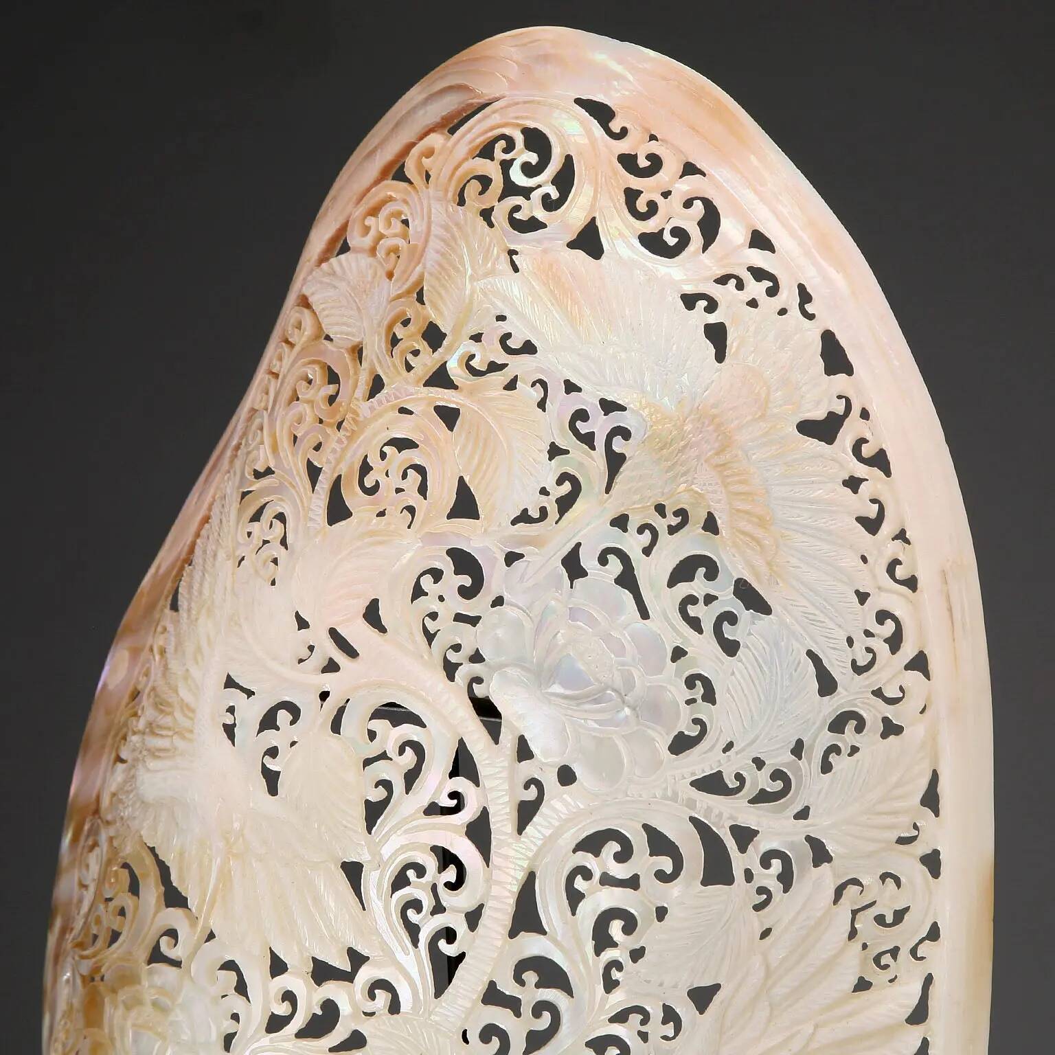Perforated shell hand-decorated on a wooden base