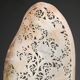 Perforated shell hand-decorated on a wooden base