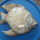 Vallauris ceramic wall sculpture of a relief fish on a blue plaque.