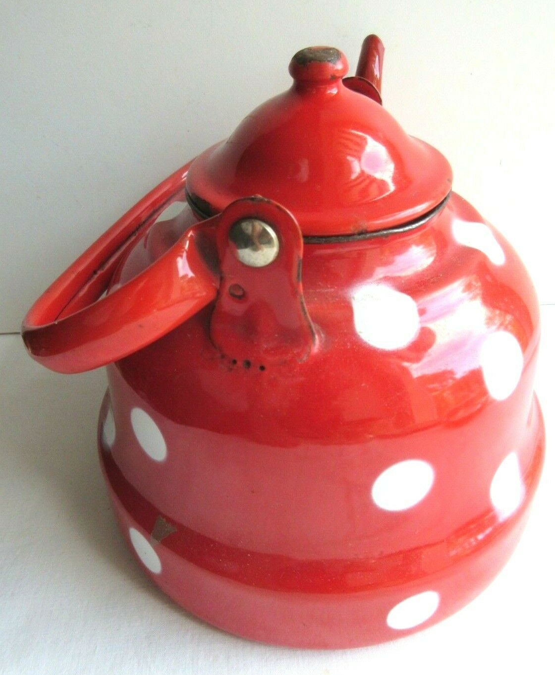 Old vintage kettle in red enamelled sheet metal, with white polka dots