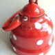 Old vintage kettle in red enamelled sheet metal, with white polka dots