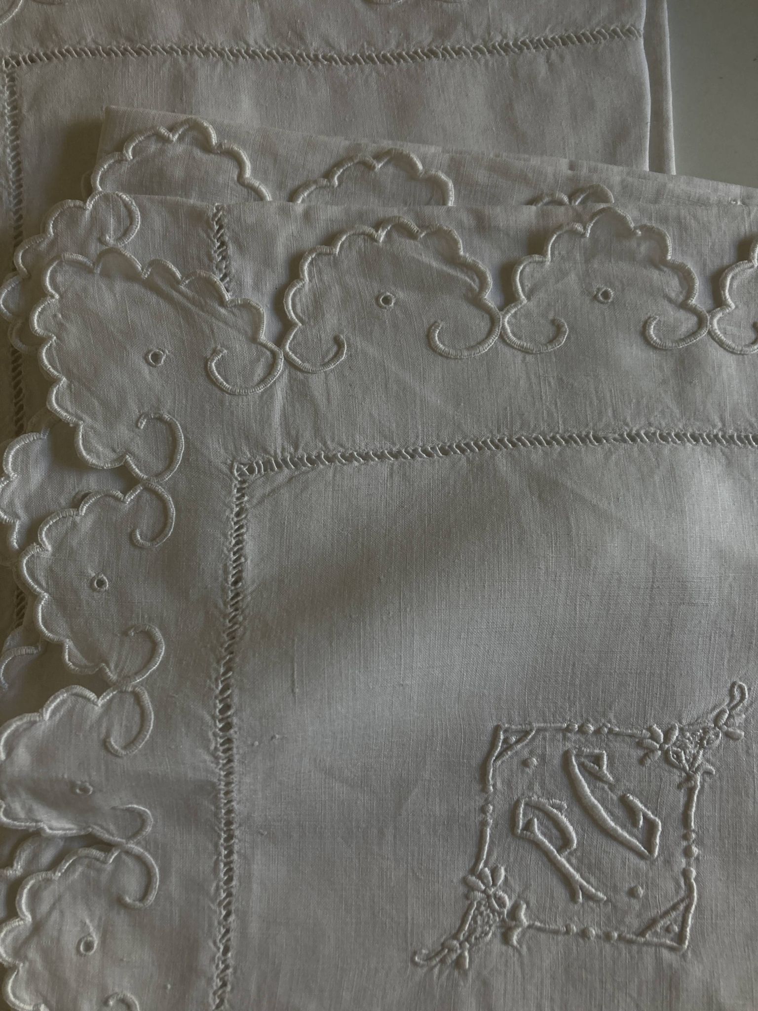 Pair of 19th-century linen pillowcases embroidered with scallops.