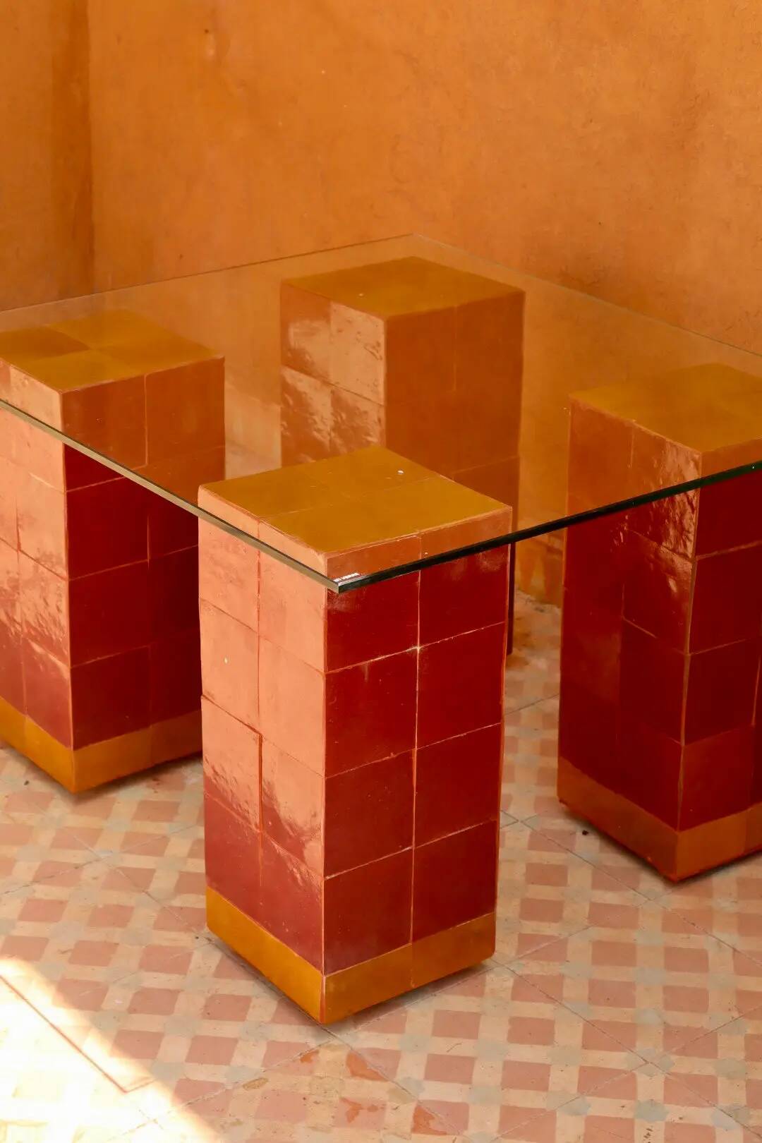 Modern coffee table in burgundy zellige with a tempered glass top.