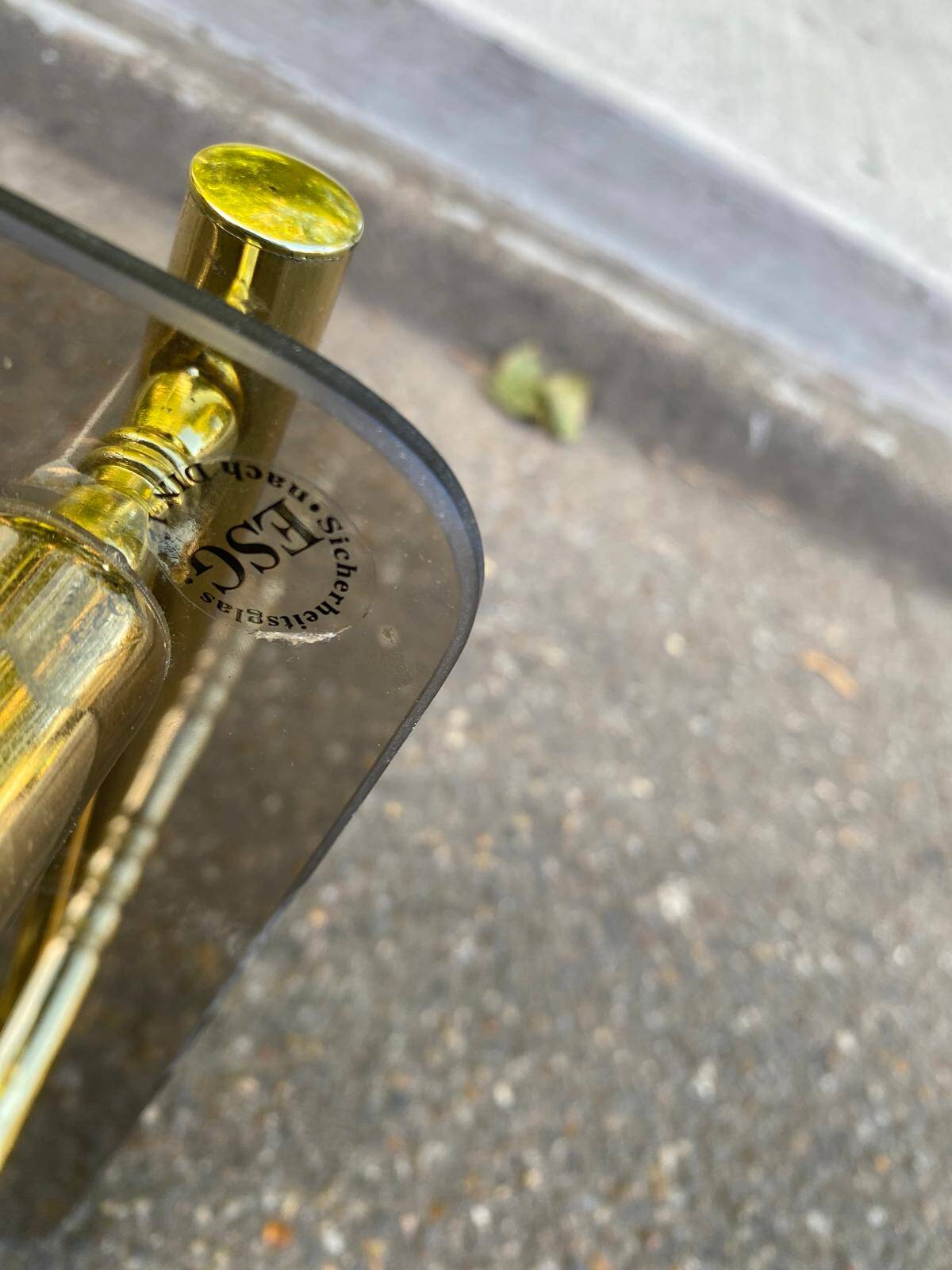 Vintage side table with smoked glass and sculpted golden brass, Hollywood Regency style.