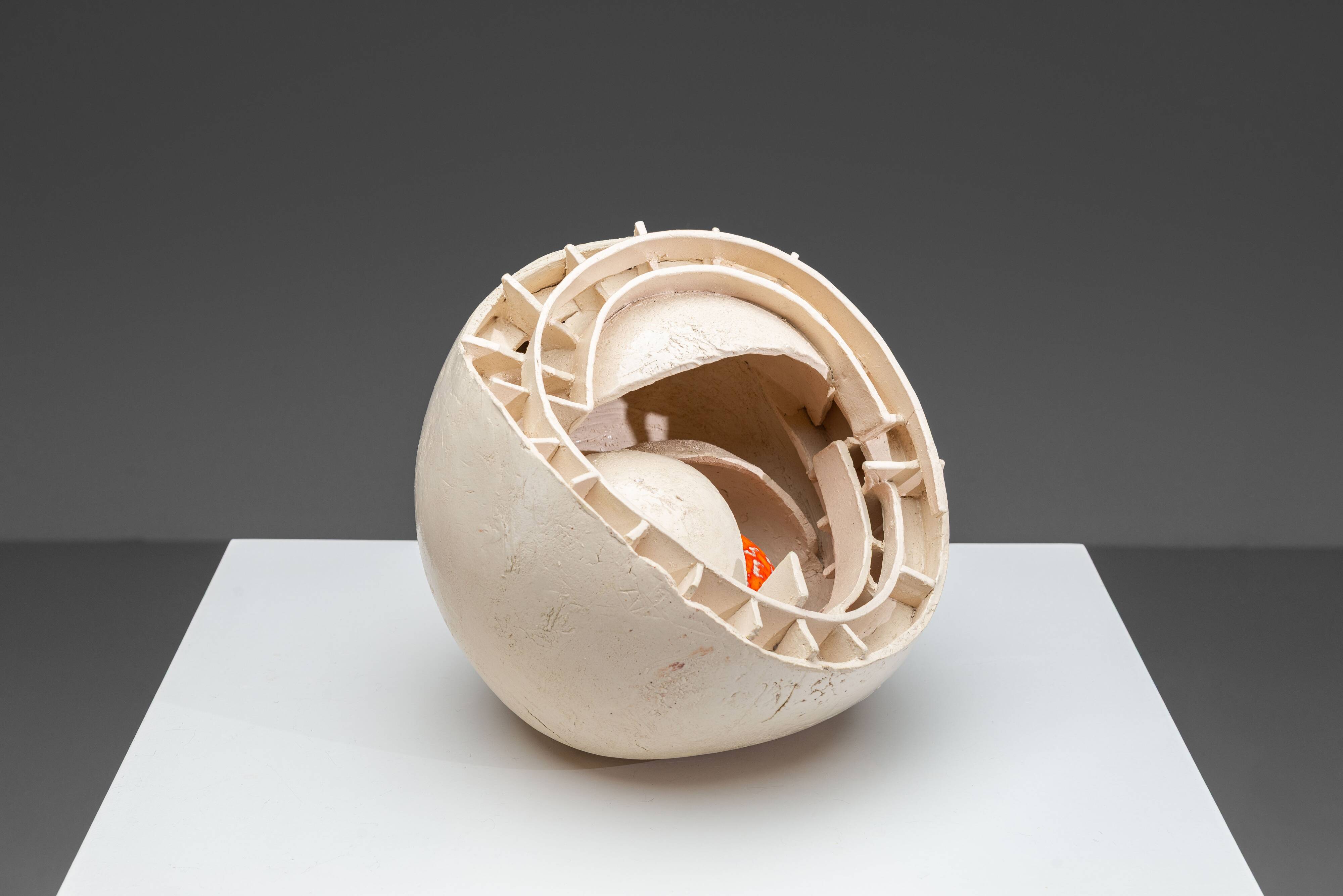 Sculpture en céramique abstraite avec un noyau orange.