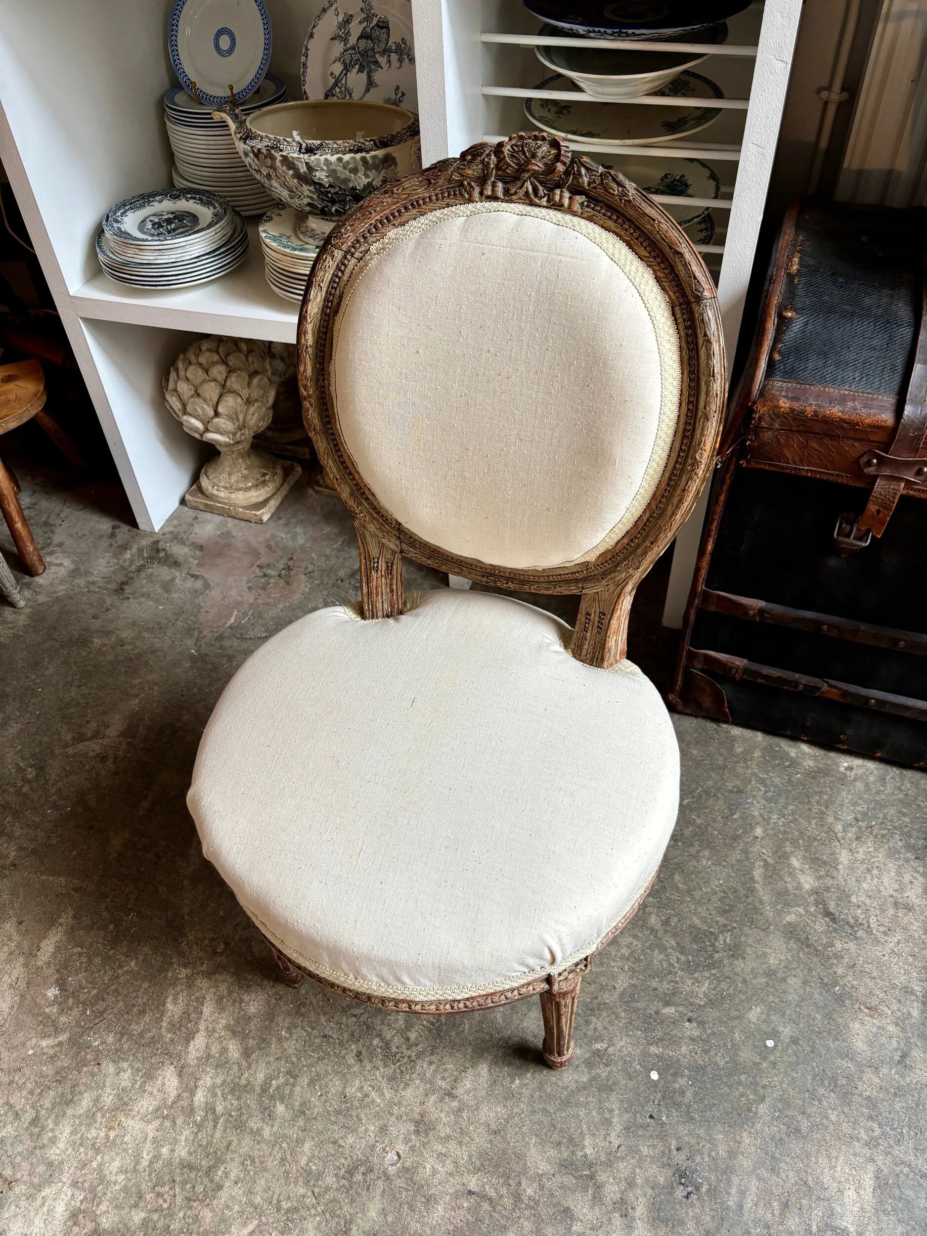 Medallion back chair in moulded wood and beige fabric.