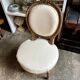 Medallion back chair in moulded wood and beige fabric.