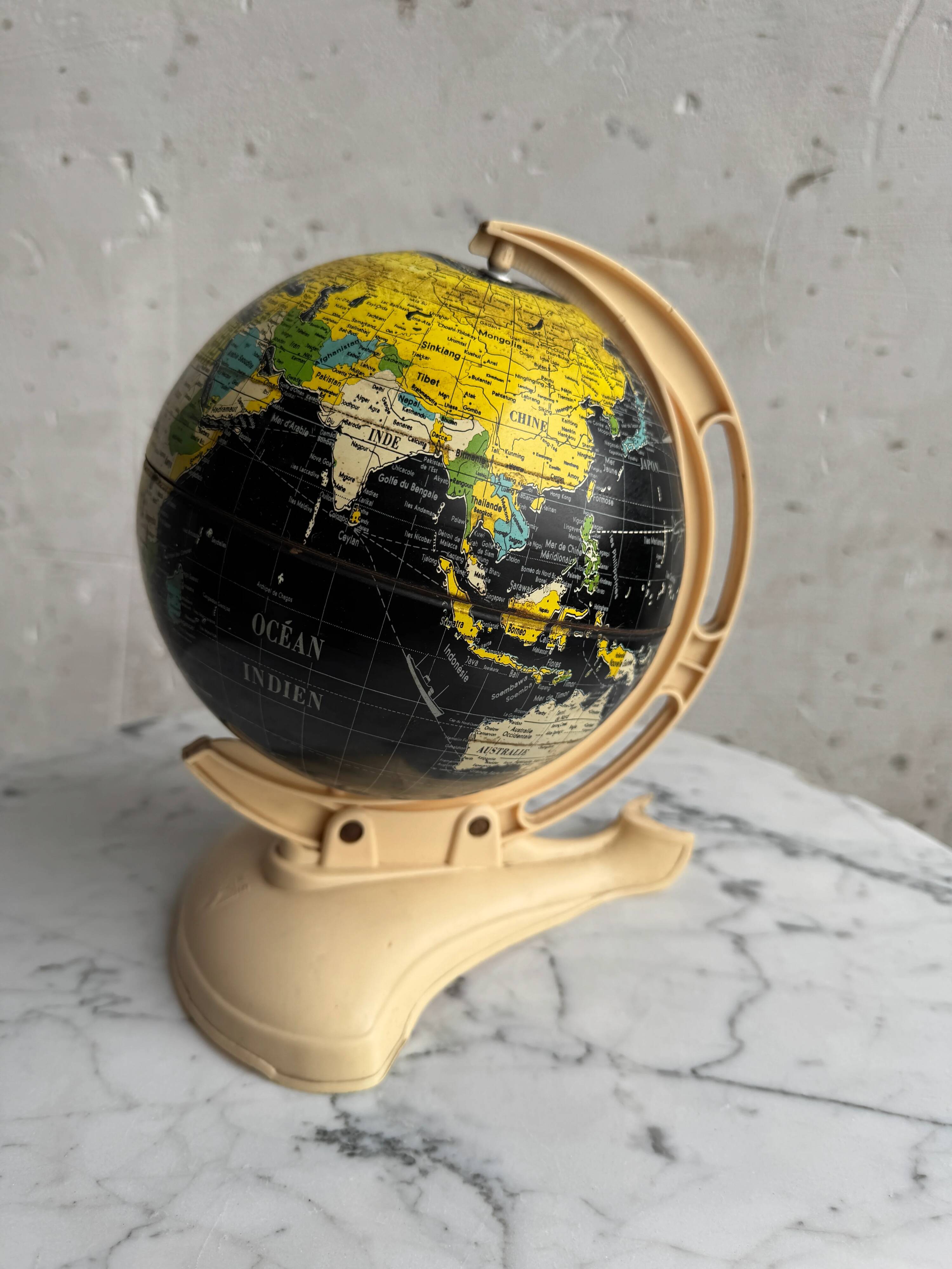 French mid-century school globe with black oceans on printed paper, cream plastic base