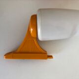 Tilting orange plastic mirror with its matching wall light