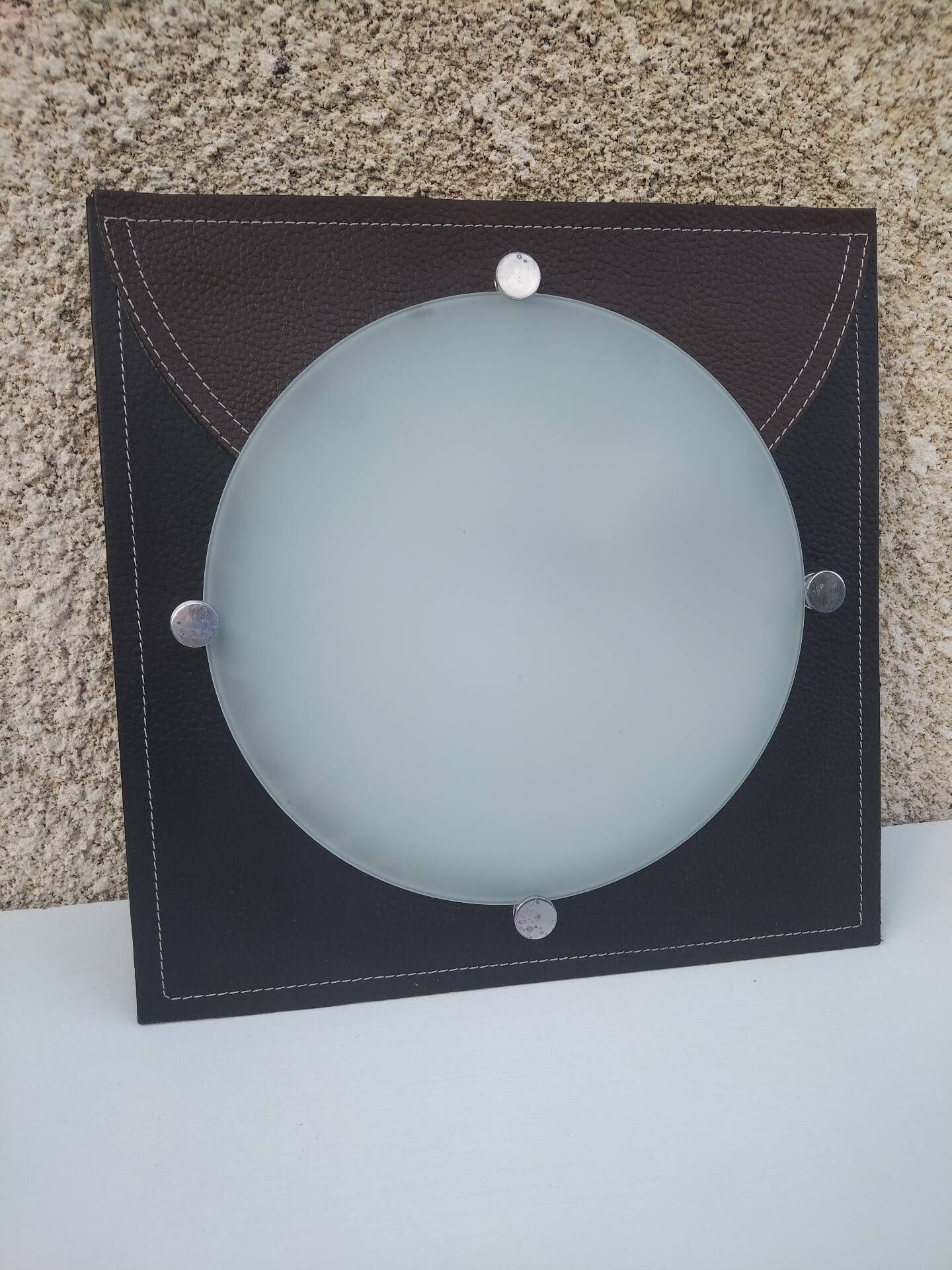 Wall light or ceiling light in frosted glass and leather-like material.
