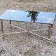 Table basse des années 70 de style néo-classique piètement métal doré et chromé plateau verre fumé
