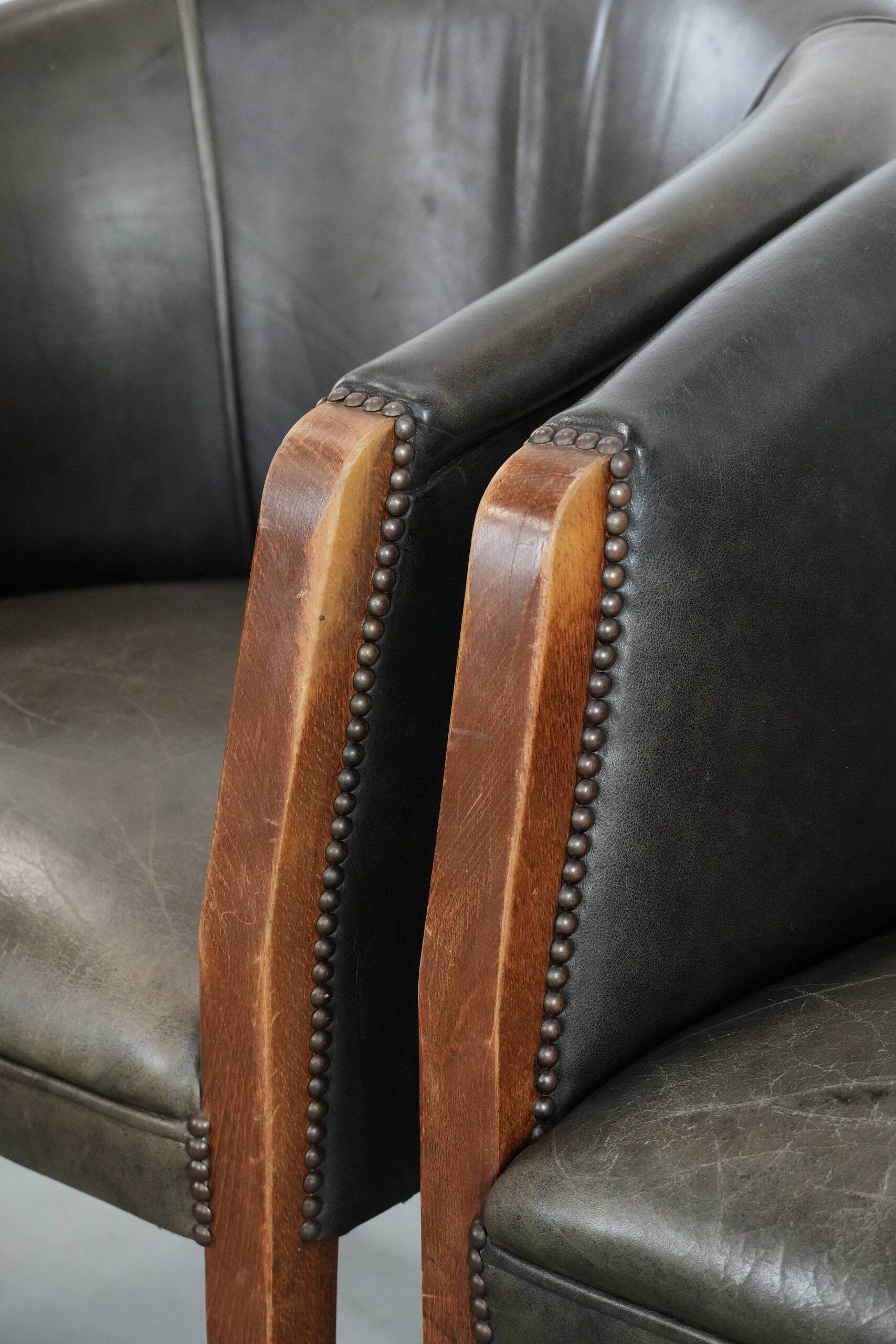 Set of two cowhide and wooden tub chairs with a sturdy colour scheme
