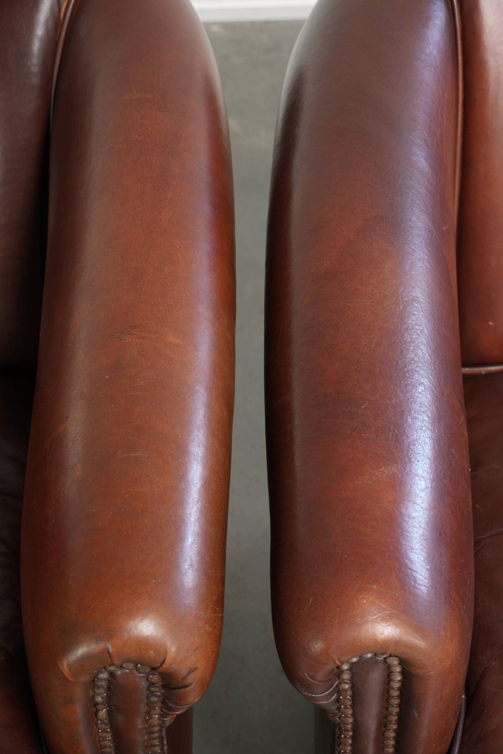 Set of 2 sheepskin club armchairs in a dark cognac colour