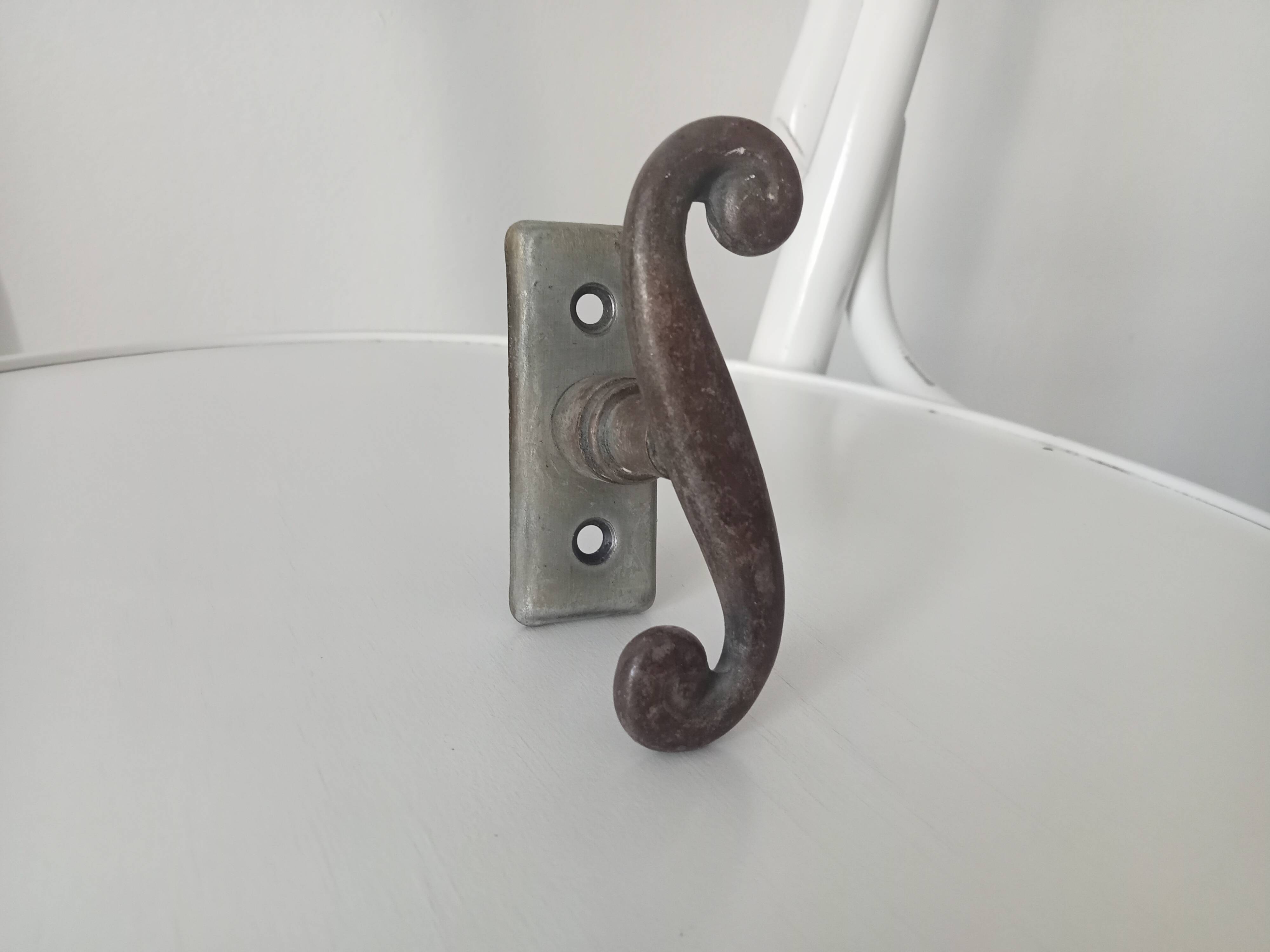 Old window handle with a forged iron cremon.