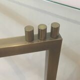 Console en acier brossé et laiton et plateau formé d'une dalle de verre. Travail français. Vers 1970