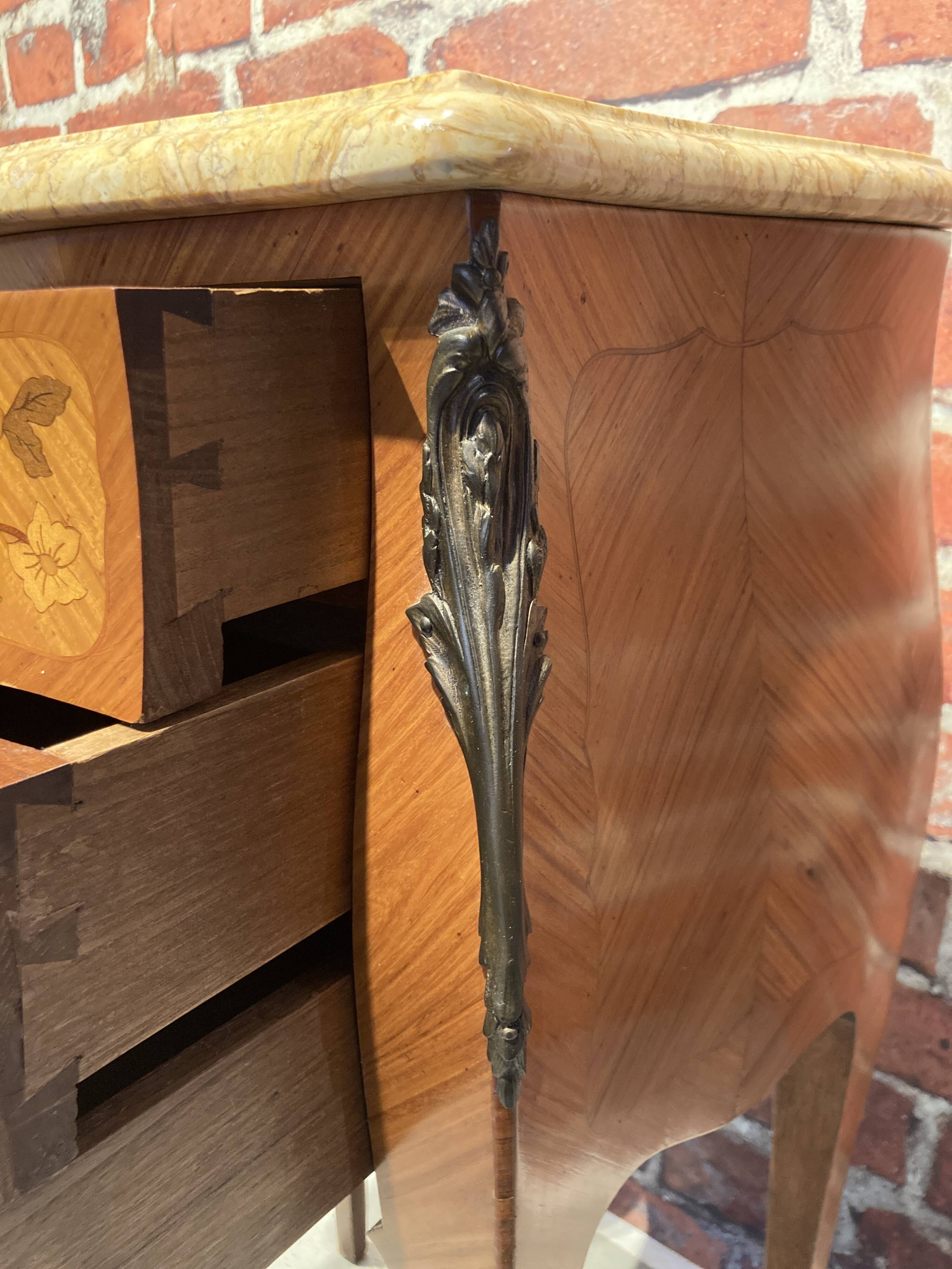 Wooden bedside table topped with a pink marble top