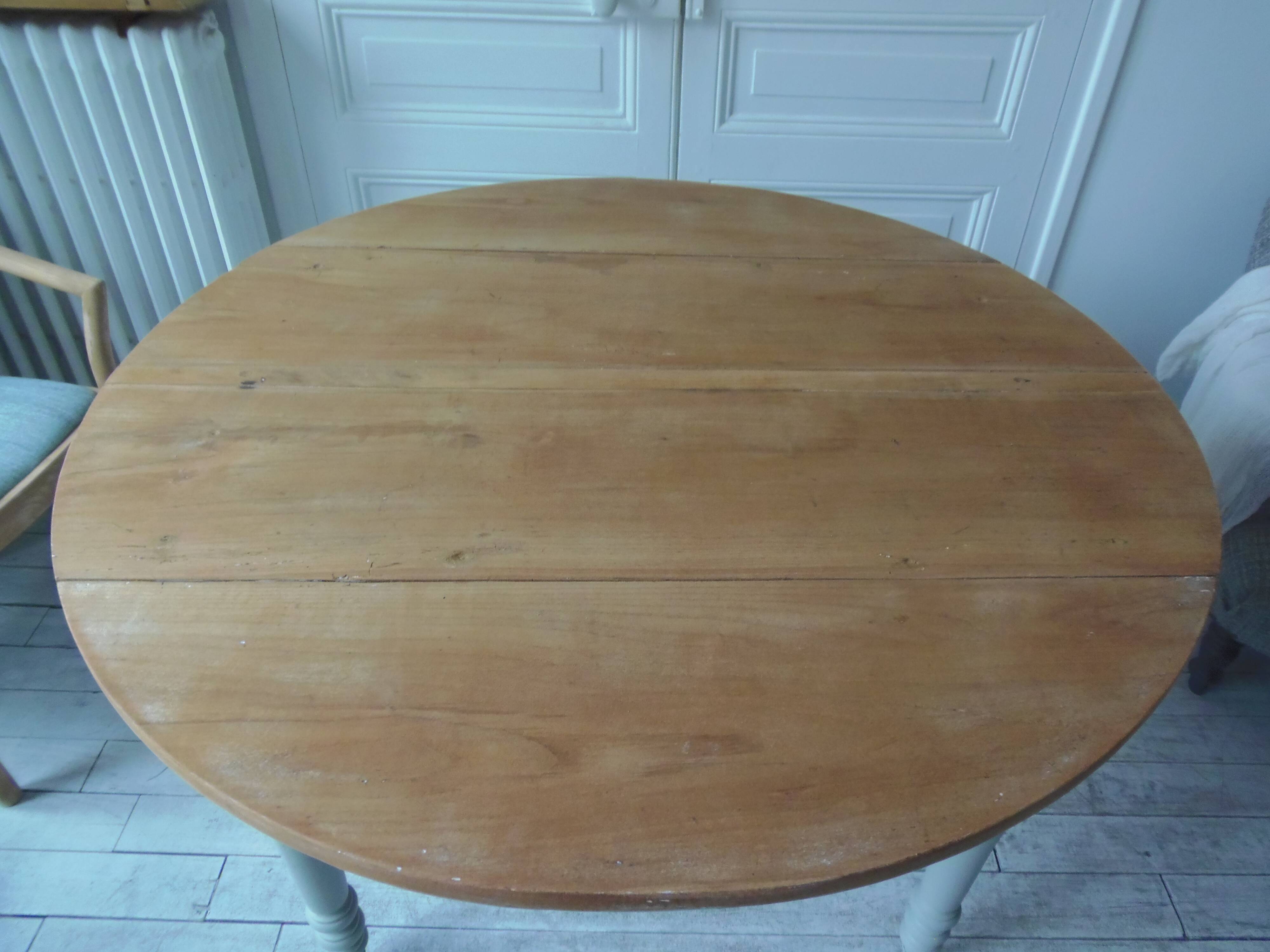 Raised walnut table with drop-leaf top, base on verdigris castors.