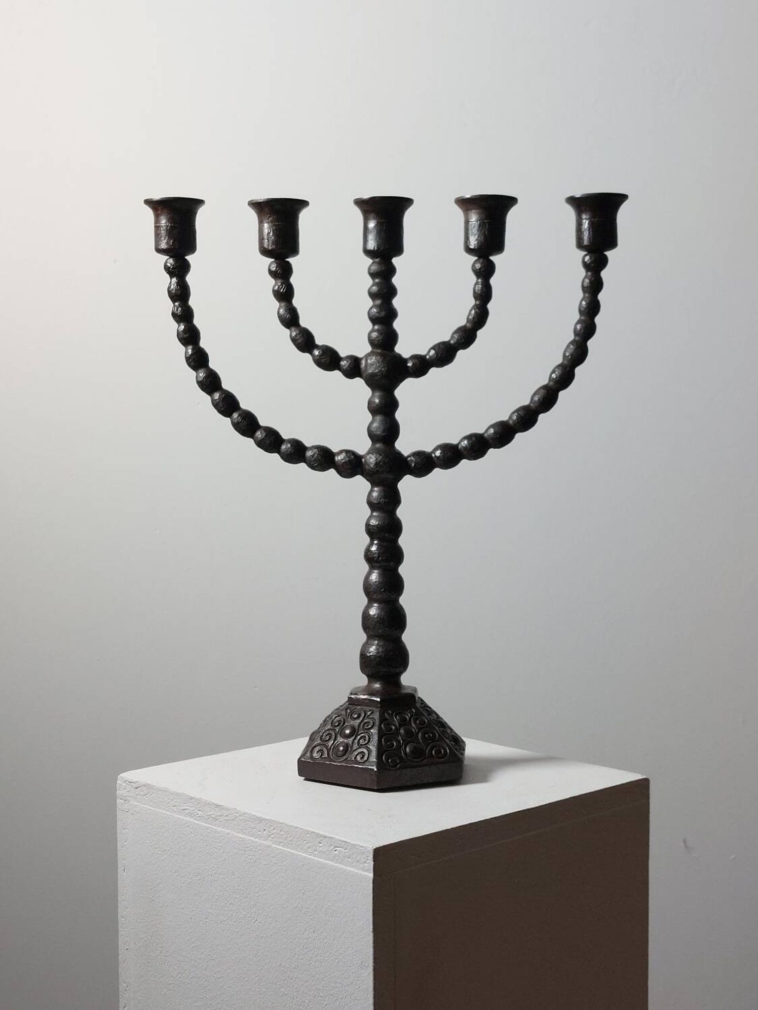 Candelabrum in the shape of a spool, skilfully forged in menorah style.