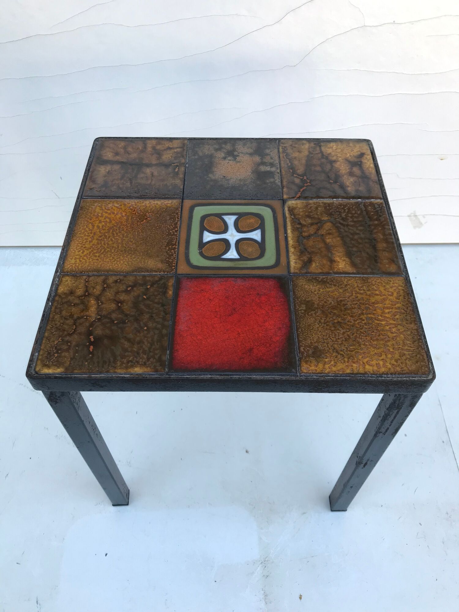 Old black metal and majolica tiles table