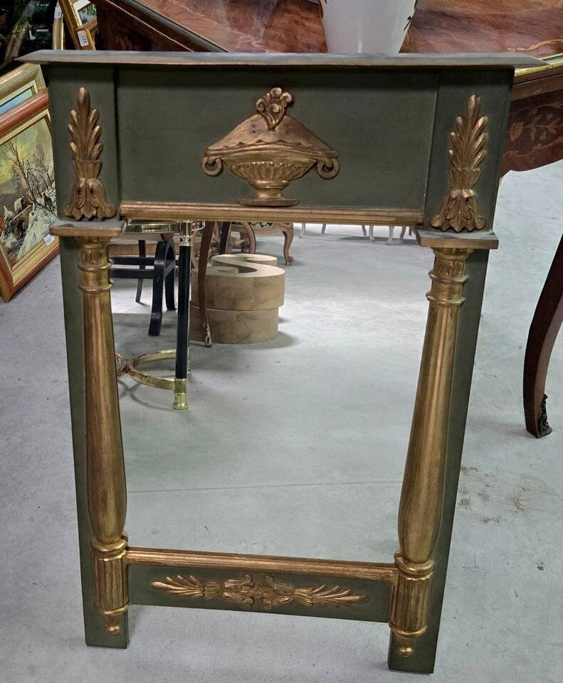 Empire-style mirror in deep green lacquered wood richly enhanced.