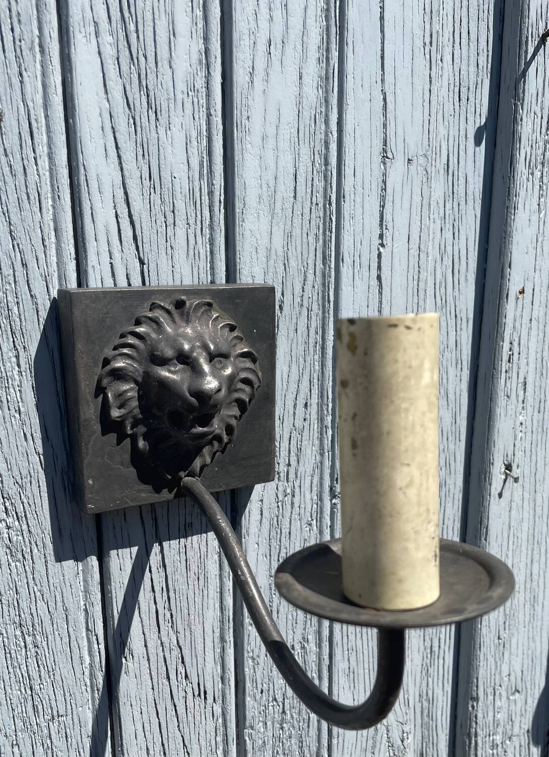 Two lion head wall sconces in tin.