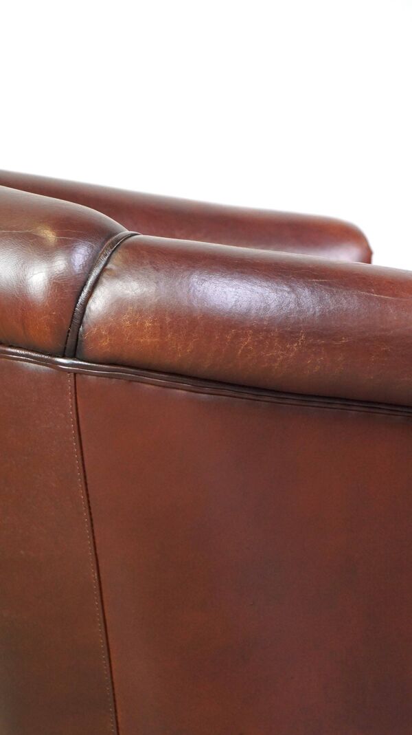 Joli fauteuil club en peau de mouton avec une belle patine