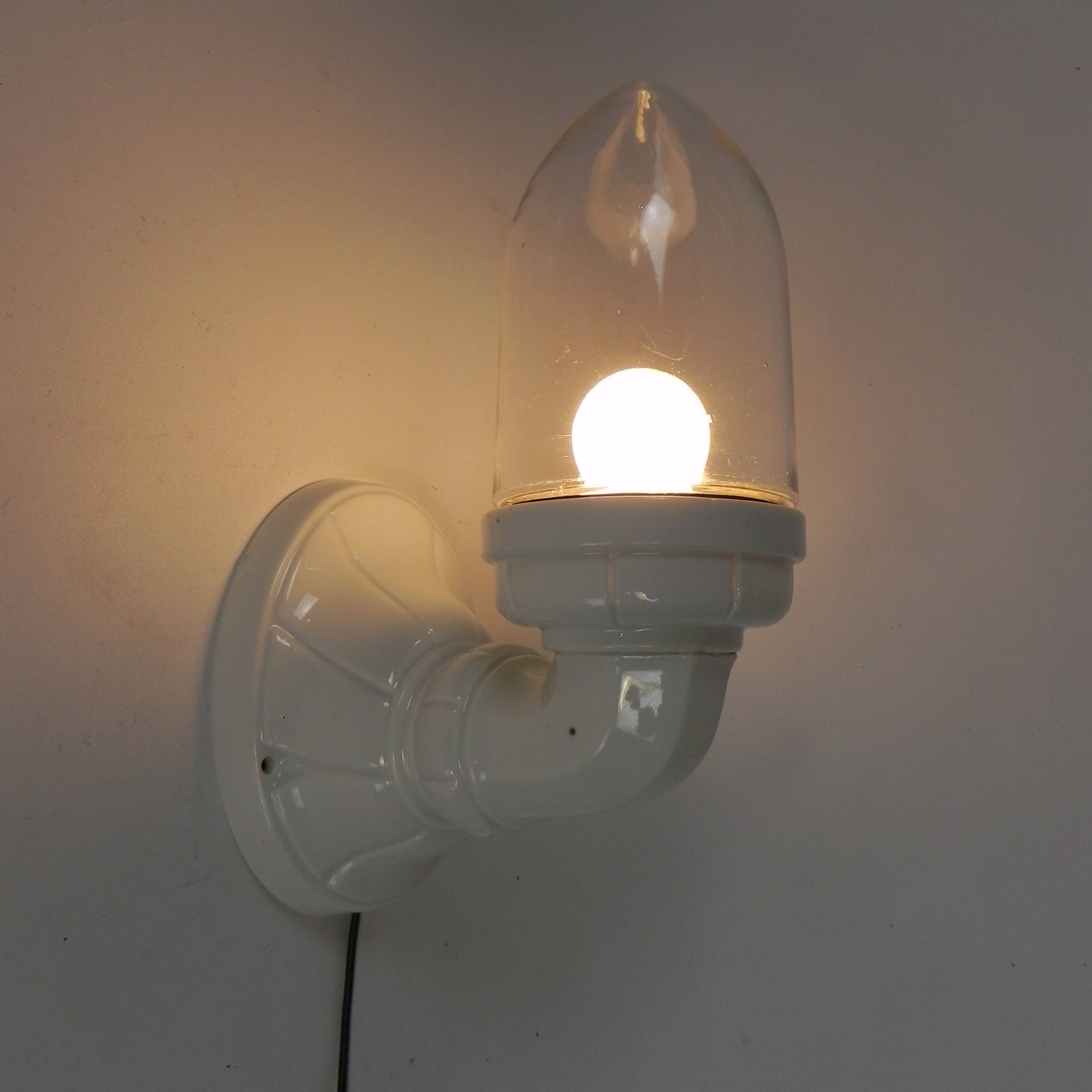 Wall lamp in porcelain with a transparent glass shade, 1930s.