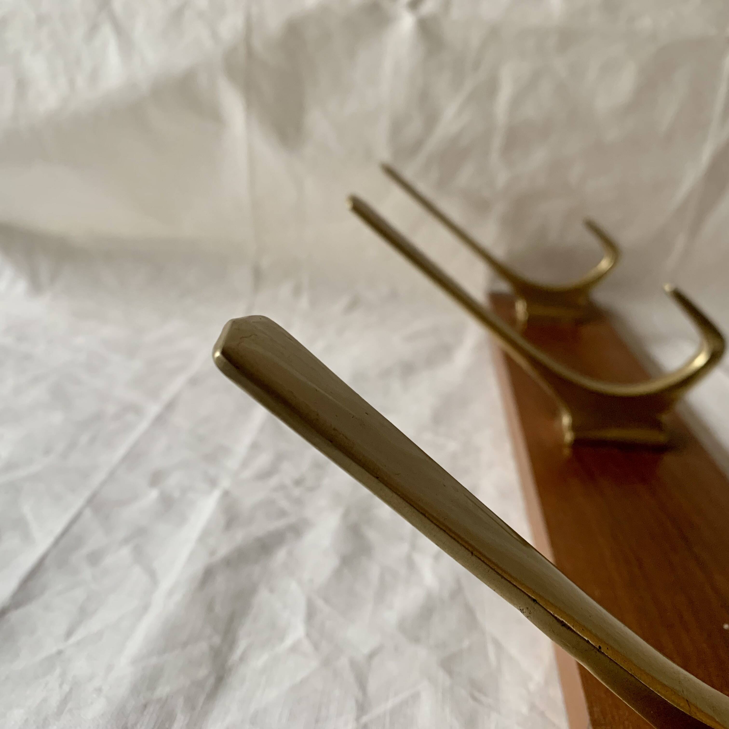 Vintage wooden wall-mounted coat rack with 3 golden cast aluminum hooks