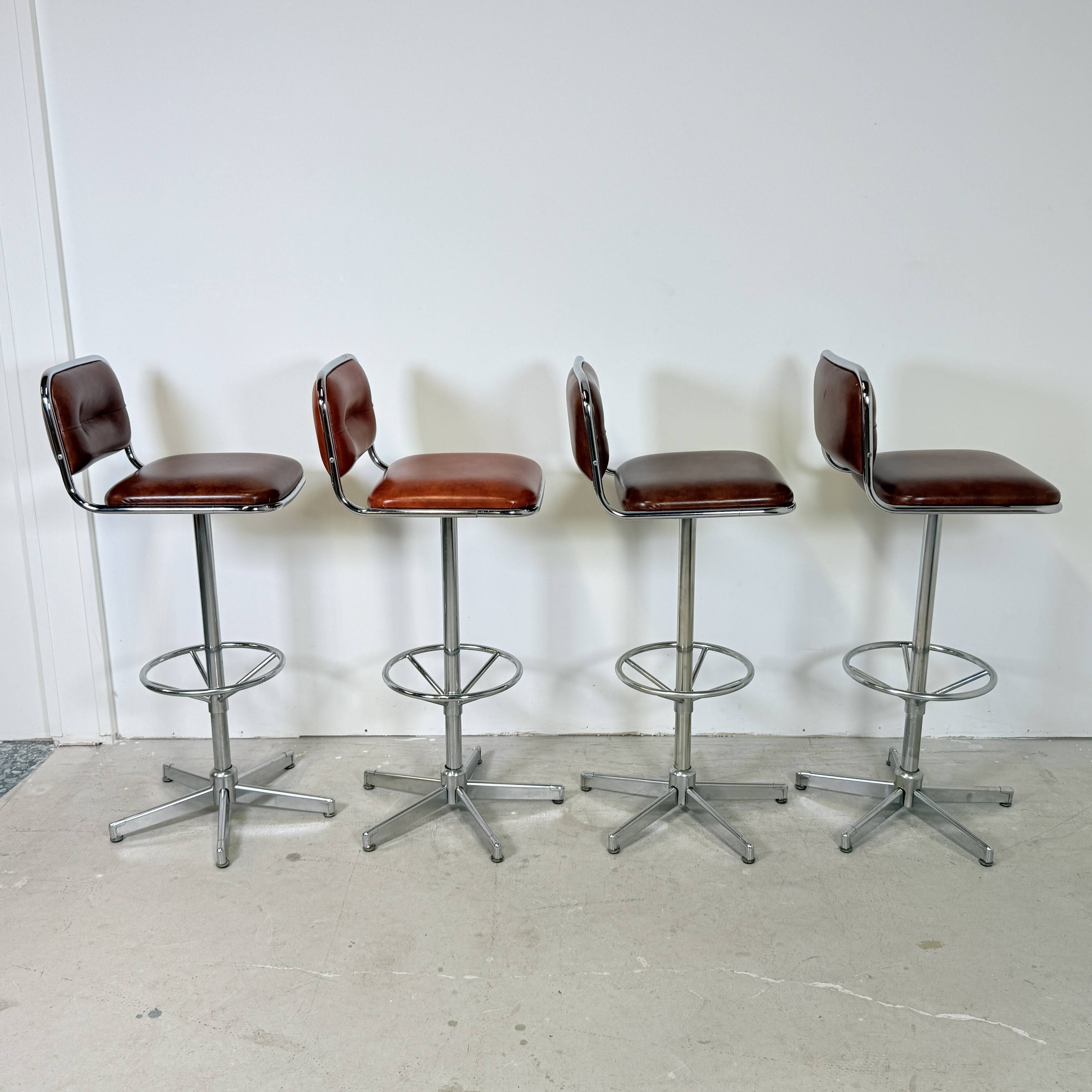 1970s chrome bar stools with cognac-colored faux leather upholstery